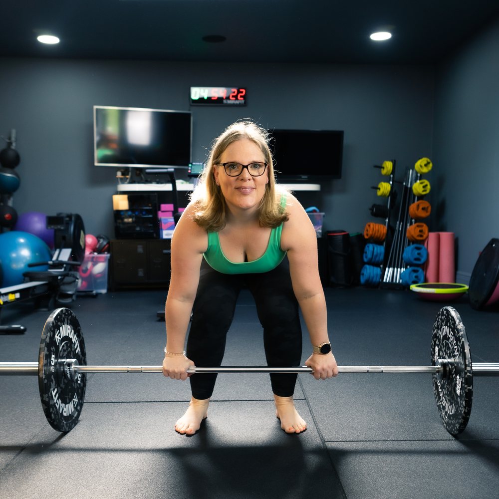 A member setting up to lift a barbell in the At Your Peak studio