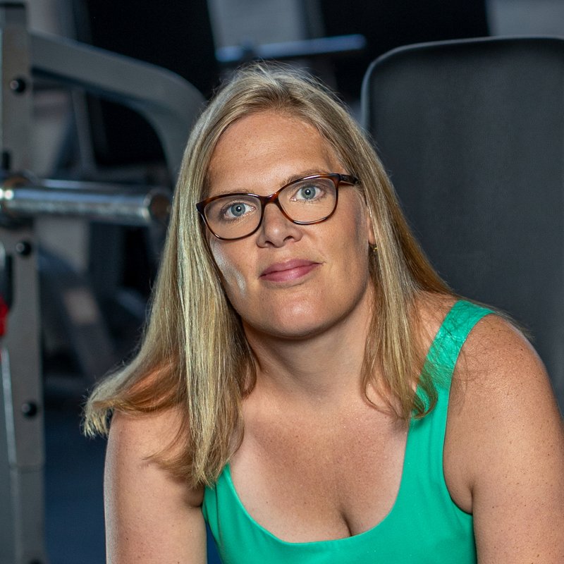 Cathrin, sitting on a bench in the gym