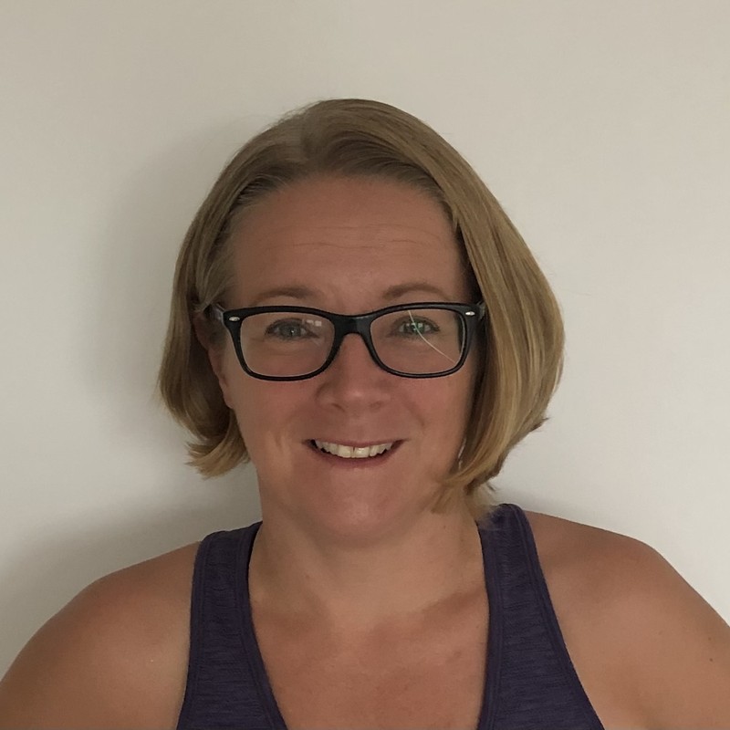 Tracey, smiling in a navy vest top